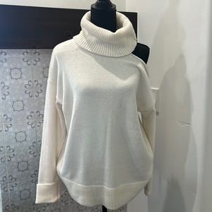 Turtle neck sweater with shoulder cutout.